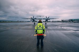 Air Traffic Controller Stands in Front of Plane