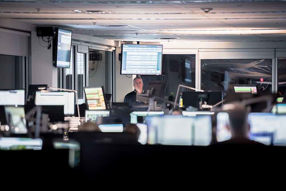 Workers in office surrounded by computers.